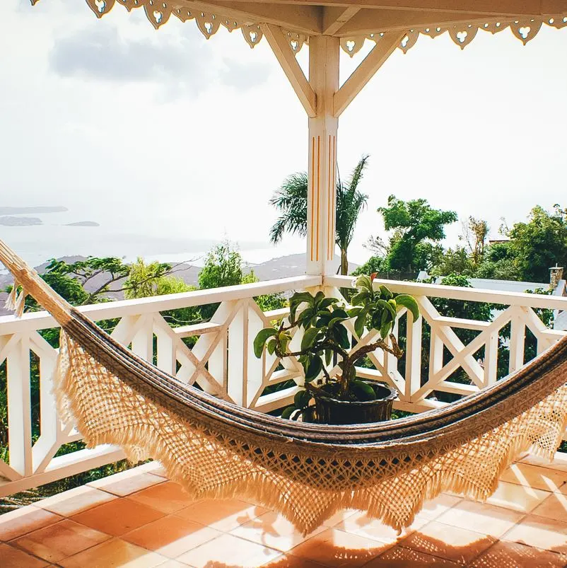 view of a balcony with a hammock in foreground and the ocean of the dominican republic in background