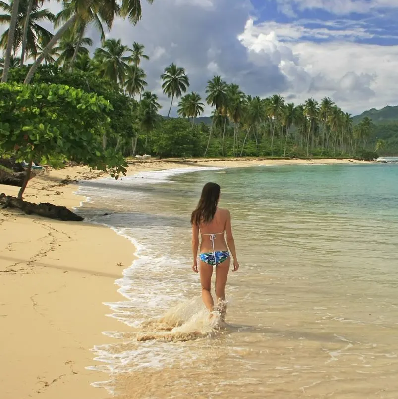 Woman walking along a beach in the Dominican Republic