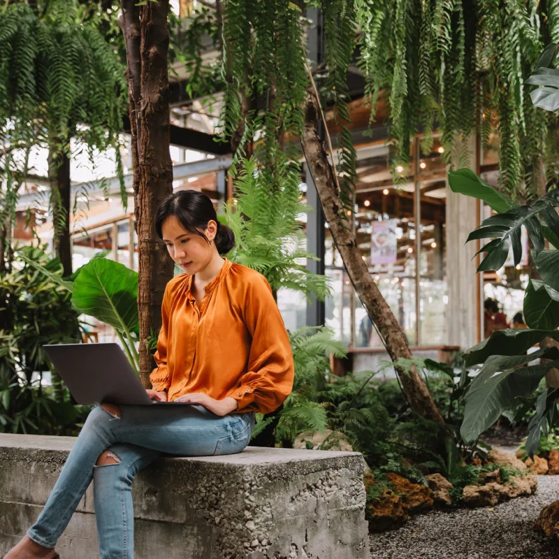 A lady working in a cafe with plants 