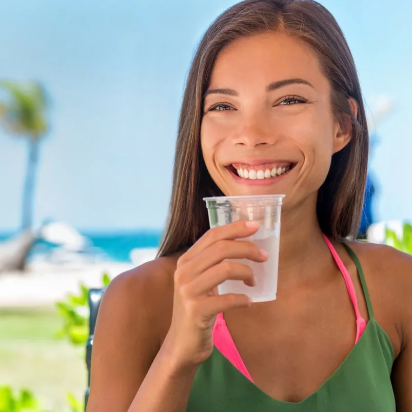 Woman enjoying a glass of water under the Caribbean sun