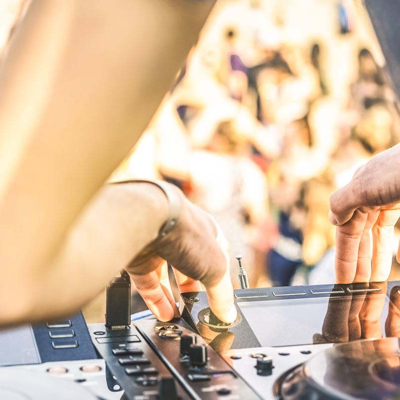 DJ playing music for a crowd at a beach