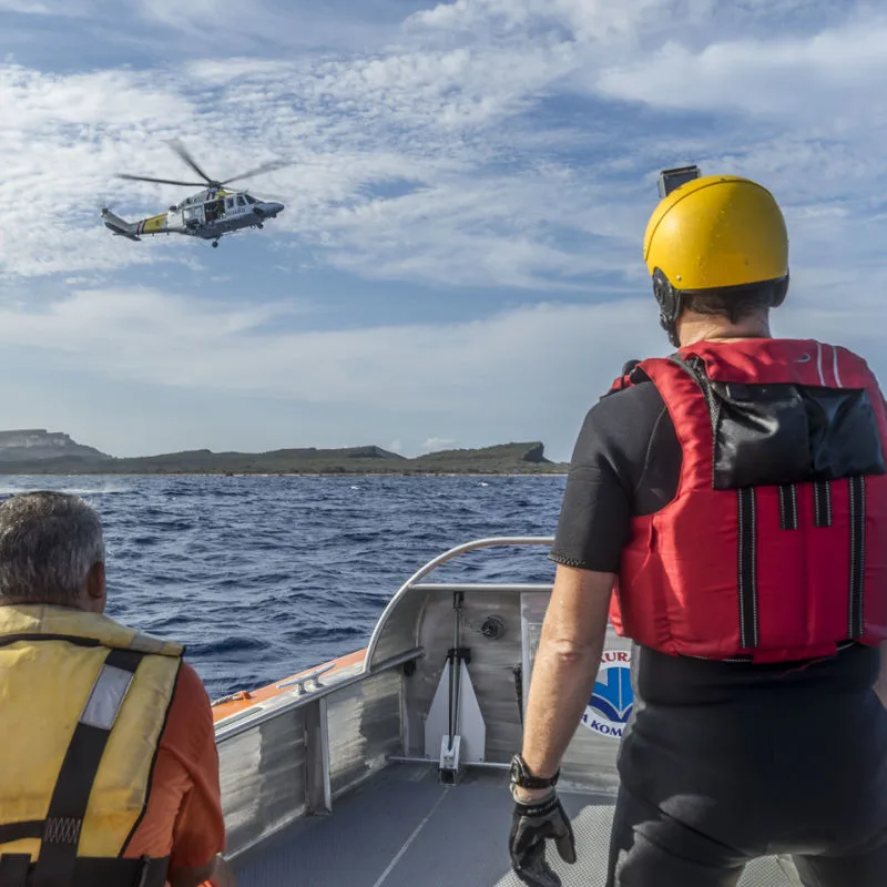 A helicopter landing at sea to look for missing victims