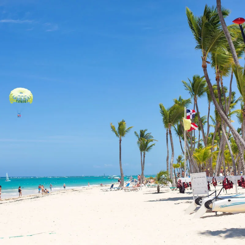 A sunny beach in punt Cana with palm trees and tourists 