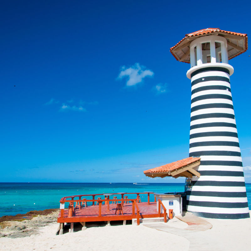 A beautiful lighthouse in a Punta Cana beach with water 
