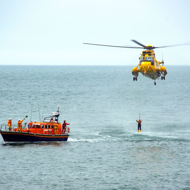 A large rescue helicopter approaching the sea to rescue someone 
