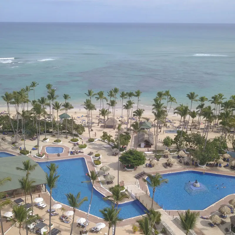 Aerial view of a resort area with pool and ocean view 