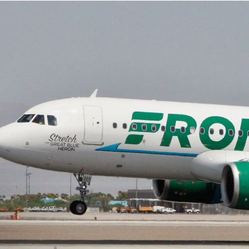 Frontier plane taking off in a large airport 