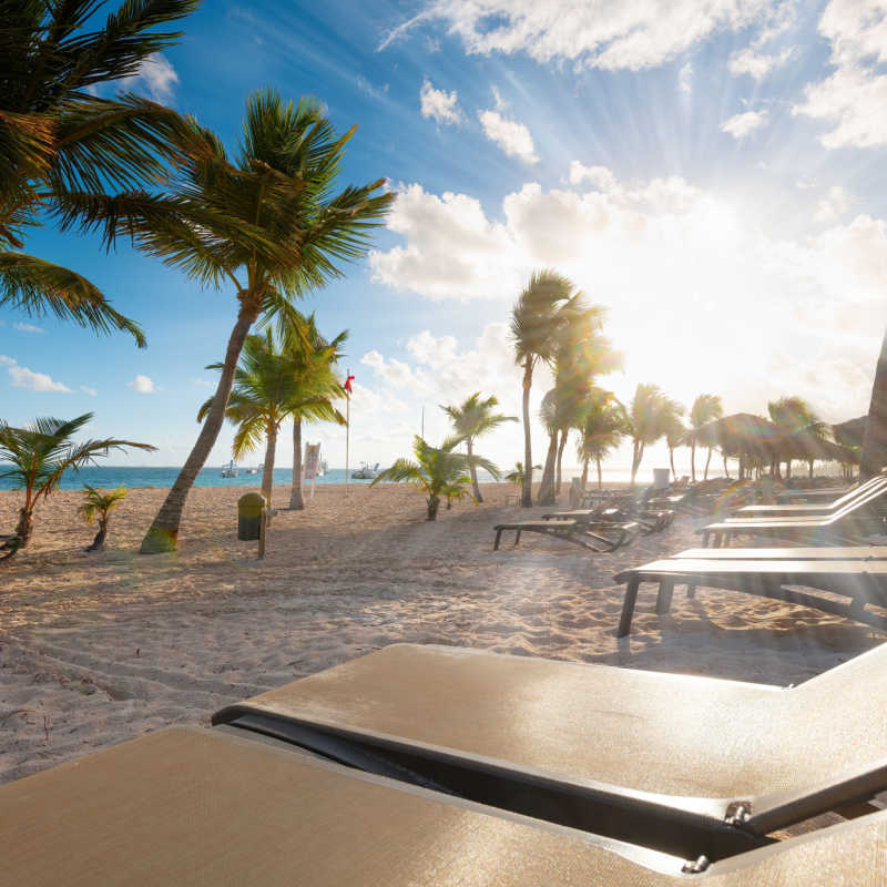 chairs in a white sand beach in punta cana with sun