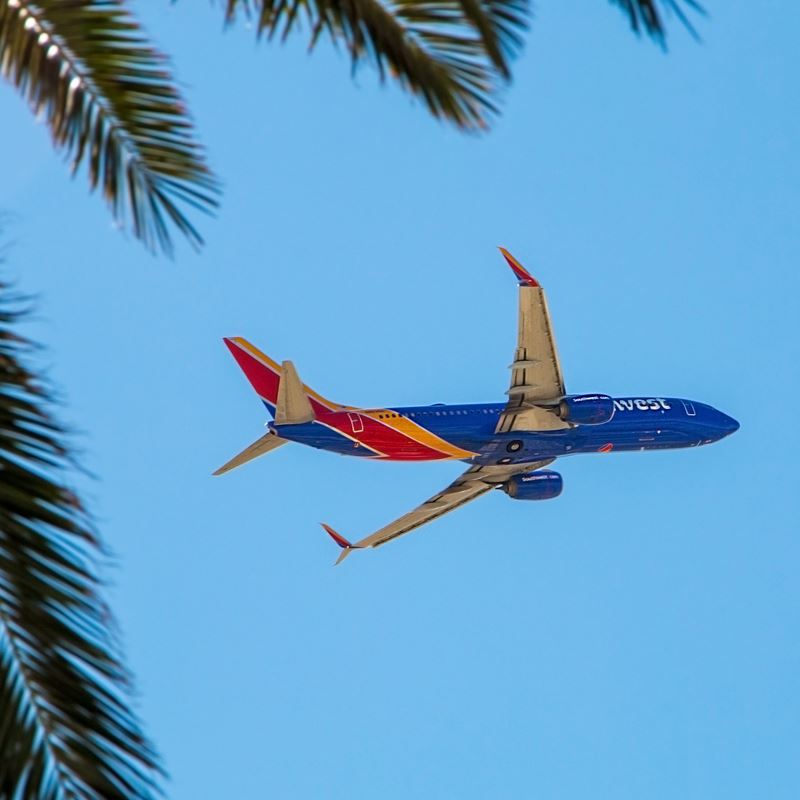 Southwest Airlines plane flying over tropical landscape